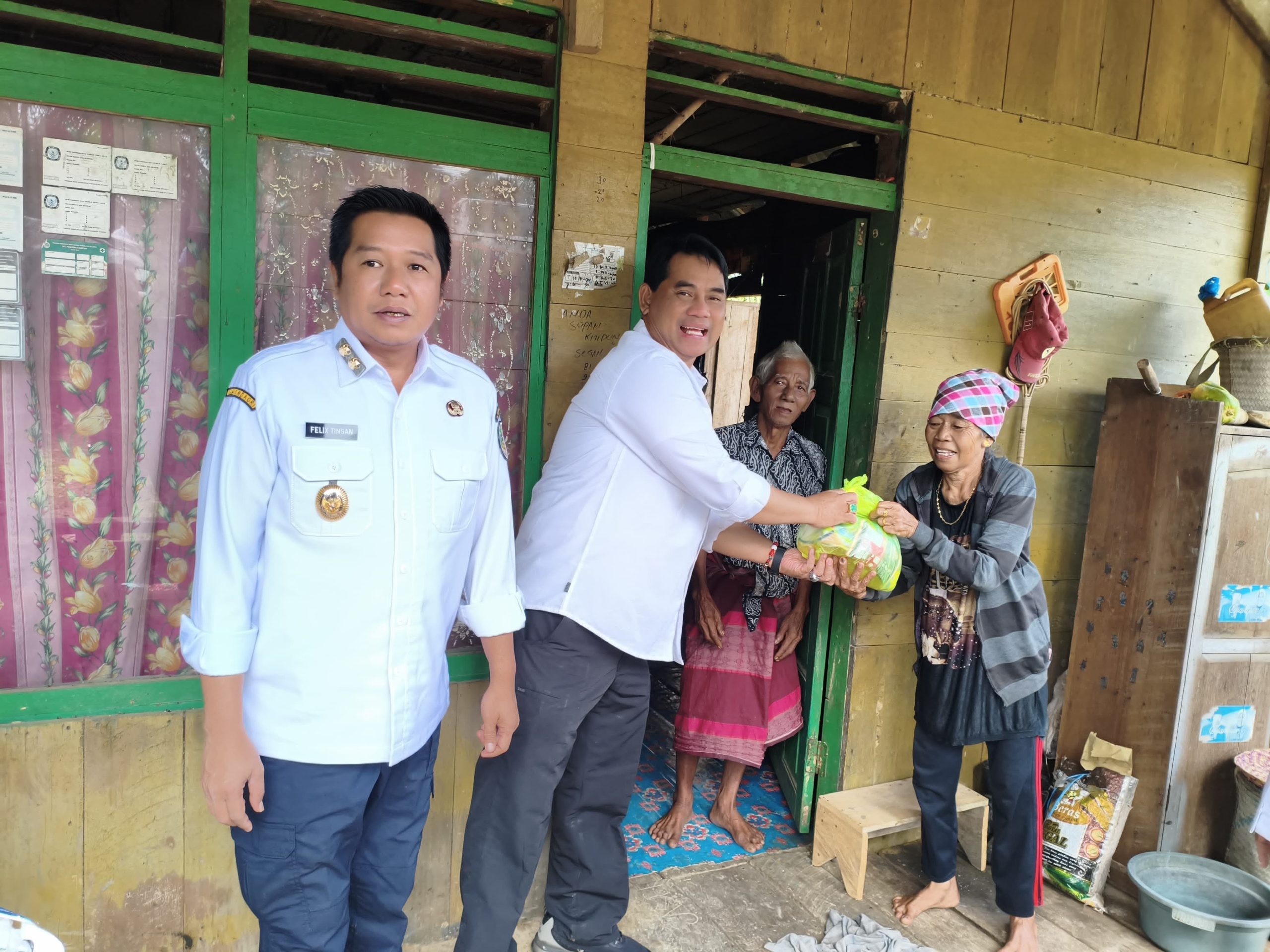 FOTO: Bupati Barito Utara Haji Shalahuddin didampingi Wakil Bupati Felix Sonadie Y Tingan saat memberikan bantuan kepada salah satu keluarga di pinggir jalan ketika kunjungan kerja ke Teweh Timur, Rabu 14 Januari 2026.(FOTO: ARNOLD)
